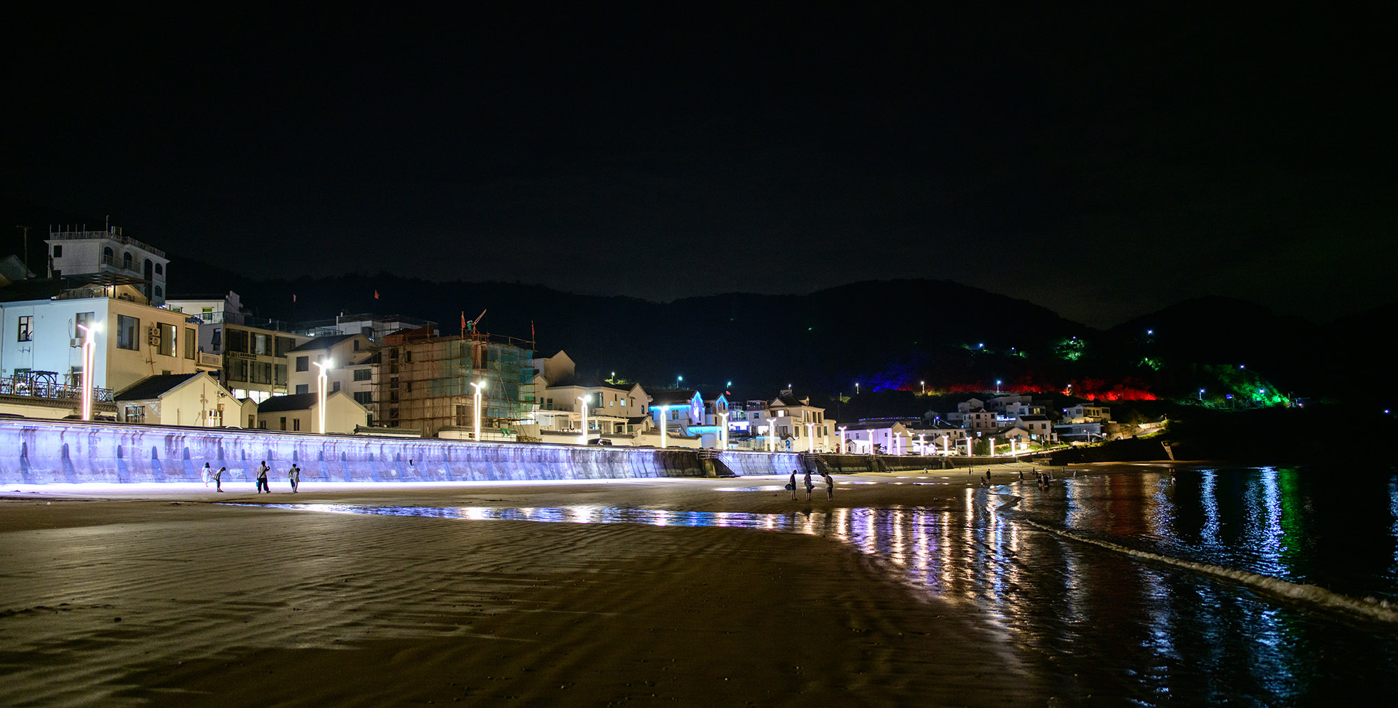 夜晚的衢山岛沙龙沙滩，灯光璀璨，有人在散步